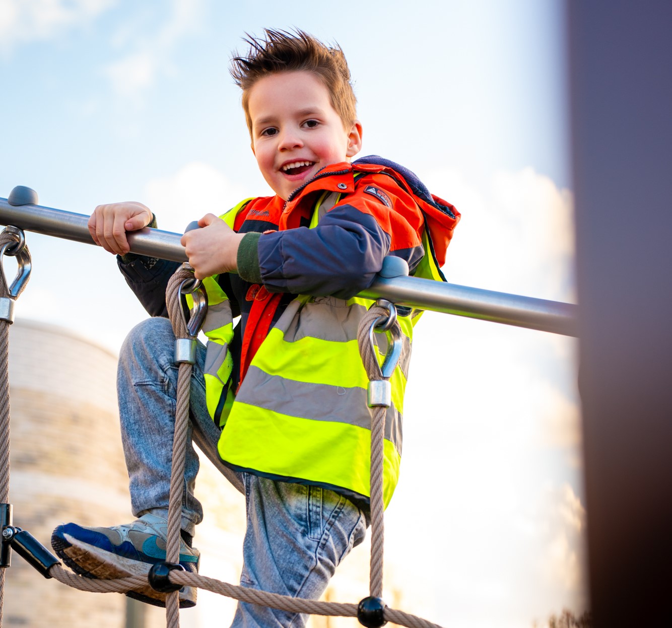 Kind klimt buiten op een klimrek